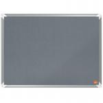 In the photograph, there is a large grey felt notice board with the brand name ACCO Brands Noticeboards Nobo written in bold letters at the top. The board is 600x450mm in size and has a premium feel to it. Multiple colorful push pins can be seen scattered across the board, holding up various pieces of paper and notes. The felt surface looks smooth and well-maintained, with no wrinkles or creases. The frame of the board appears to be sturdy and well-constructed, with a sleek and modern design. Overall, the photograph showcases a high-quality and professional-looking notice board that would be suitable for any office or workspace.