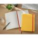 The photograph displays a bright and warm yellow ACCO Brands Leitz Cosy Notebook with a soft touch ruled cover. Its hardcover adds durability, while the ruled pages provide a structured writing space. The cozy notebook exudes a sense of comfort and style.