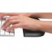 The image shows a black wrist rest designed by Kensington for use with slim and compact keyboards. It features a soft and ergonomic design to provide comfortable support for the wrists while typing. The wrist rest has a smooth surface and is contoured to fit the shape of the wrists. It is made by ACCO Brands and is specifically designed for improved wrist comfort during computer use.