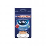 In the photo, there are multiple brown, square-shaped tea bags with the word Tetley stamped on them. The bags are stacked neatly on top of each other in a pack of 440. Behind them is a bright red background with the words One Cup Tea Bags written in white. A small label with the word Tetley can be seen in the corner of the photo.