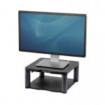 This image shows two Fellowes monitor stands and dust covers in black. The monitor stands are stacked on top of each other, with the top stand featuring a premium riser design. The dust covers are positioned on top of the stands, adding protection and a clean look to the setup.