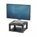 This image shows two Fellowes monitor stands and dust covers in black. The monitor stands are stacked on top of each other, with the top stand featuring a premium riser design. The dust covers are positioned on top of the stands, adding protection and a clean look to the setup.