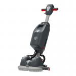 The picture shows a Numatic 244NX Scrubber Dryer with one battery on top of it. The vacuum cleaner has a shiny, sleek black and blue design with a large cleaning pad attached to the bottom. It is placed on a clean, tiled floor with some scattered dust and debris around it.