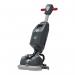 The picture shows a Numatic 244NX Scrubber Dryer with one battery on top of it. The vacuum cleaner has a shiny, sleek black and blue design with a large cleaning pad attached to the bottom. It is placed on a clean, tiled floor with some scattered dust and debris around it.