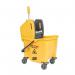 In the picture, there are two sturdy, white buckets with black handles labeled Blake & White Buckets. One bucket has a yellow 25 Litre label on it. There is also a yellow mop bucket with a smiley face symbol on it, labeled Purely Smile Kentucky Mop Bucket and Wringer. The buckets and wringer are all placed on a clean, shiny surface.