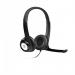 The image shows a set of Logitech headsets, specifically the LGT-H390 model, with the 981-000406 product code, resting on a surface. The headsets are mostly black with silver accents and feature soft padding on the ear cups and headband for comfortable use. The microphone boom can be seen attached to the left ear cup, and there is a volume control and mute switch on the cord.