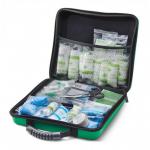 The photo shows a large, red Feva case with the words Click Medical First Aid on it. Inside, there is a medium-sized first aid kit with various medical supplies and equipment neatly organized. The kit is labeled with the BS8599-1 standard.