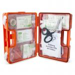 The photograph captures a compact and well-organized first aid kit designed specifically for German workplaces. It includes all the necessary essentials for up to 50 employees, neatly arranged and clearly labeled for easy access in case of emergencies.