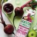 This photograph shows a stack of six recycled glass bottles filled with Cawston Press Brilliant Beetroot Juice. The vibrant pink-red liquid is freshly pressed and looks refreshing. The label features a bold, hand-drawn illustration of a beetroot.