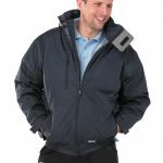 The image shows a navy blue Beeswift Mercury bomber jacket in size small/medium. It is weatherproof and made of beeswift material. The jacket has a stylish bomber silhouette and a high collar with a zip closure.