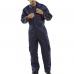The photograph shows a navy blue Beeswift boilersuit with a quilted design. The fabric has a shiny finish and the fit appears to be loose and comfortable. Embroidered with the brands logo, the boilersuit has several pockets and a zipper closure. It looks sturdy and well-made.