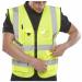 The photo shows bright yellow Beeswift high visibility vests for added safety in low light environments. The Executive Hi Viz Waistcoat features a reflective band for increased visibility. This vest is a size 5XL and part of the Saturn Yellow collection.