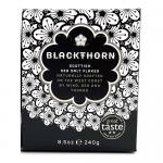 Twelve 240g boxes of Blackthorn Salt are arranged in a tight grid on a neutral surface, each box bearing the Blackthorn logo, a minimalist salt illustration and standard labeling. Soft shadows and even lighting emphasize the clean, orderly presentation. Front faces are visible with minor creases...