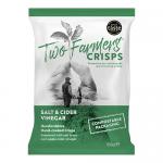 An open cardboard carton displays twelve 150g Two Farmers Salt & Vinegar crisp bags. Each bag shows the Two Farmers logo and bold Salt & Vinegar text, stylized potato crisps imagery, green-and-white packaging and seasoning splash graphics. Lighting highlights bag textures and glossy printed labels.