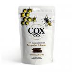Photo shows six Cox&Co. Bee Pollen & Honey chocolate sharing pouches arranged in a fan. Each glossy pouch features the Cox&Co. logo, honey-gold accents, a honeycomb graphic with pollen specks and glossy dark chocolate shards pictured on a warm brown background. Clear product text appears.