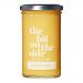 A cluster of six glass jars of lemon curd sits on a light tabletop. Each jar displays a pale yellow, glossy curd visible through clear glass, topped by a cream lid. Labels show simple lemon illustrations, bold brand text and subtle decorative accents.