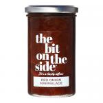 A cardboard tray holds six glass jars of The Bit on the Side Red Onion Marmalade, each jar showing deep crimson preserve and a white label with red and black typography. Metal lids reflect light; the pack displays brand logo, product name and a chutney & condiments banner Background is neutral grey