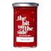 Six clear glass jars of chilli jam sit in two neat rows, revealing deep ruby-red preserves. Each jar wears a silver metal lid and a white label displaying bold black brand lettering, a small red chilli illustration and fine ingredient text. Light glints on the glossy glass.