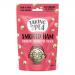Photo shows a 125g Taking the Pea Smoked Ham sharing bag with bold logo and pink-green packaging. An illustrated ham and peas decorate the front. The torn bag lies open, spilling ridged crisps across a wooden board; seasoning flecks and texture are visible.