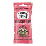 Photo shows a neat display of twelve 25g pod packs of Taking The Pea crisps in Smoked Ham flavor. Each slim packet features green pea graphics, a ham illustration and crisp imagery; several pods lie flat while others stand, exposing packet fronts and backs.