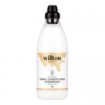 Six tall translucent green 1L bottles with curved shoulders and flip-top caps stand in a neat row on a clean white background. Labels display the Wilton London logo, cedarwood botanical illustration and eco icons; glossy plastic catches soft studio light.