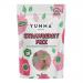 Seven bright pink Yumma candy pouches fan across a white background, each glossy pouch showing a large strawberry illustration, effervescent fizz bubbles and scattered red candy pieces. The bold Yumma logo and playful typography stand out on each pouch Soft reflections and faint creases add texture