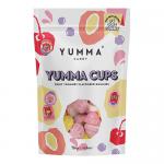 Brightly colored pouch displays seven Yumma Cups visible through a clear window; glossy wrappers show swirls of pastel pink and orange. A bold logo sits at the top, small icons and text run along the bottom, and playful candy illustrations decorate the background. Soft highlights add gentle depth now