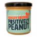 A row of six clear jars with cheerful yellow lids and bright labels shows a smiling squirrel mascot. Smooth peanut spread peeks through the glass, rich amber-brown in tone. Labels display playful typography, peanut illustrations and splash graphics; soft lighting adds warm highlights. Subtle shadows