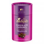 Photo shows six dark chocolate caramel truffles in a branded box and loose on a wooden board. Glossy dark shells glisten, a few truffles reveal gooey caramel centers. Packaging bears Joe & Seph’s logo and a 100g label against a neutral background.