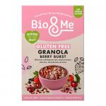 A vibrant resealable pouch stands upright, showing the Bio&Me logo at the top. Illustrated berries burst across the front beside visible clusters of golden granola through a clear window. A gluten-free badge and nutrition icons appear near the base against a neutral background. Soft light adds depth