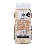 An upright squeeze bottle features a flip-top cap and slightly tapered neck. The clear plastic reveals creamy beige sesame-butter sauce. A glossy label wraps the center, displaying the Med Cuisine brand, product name, stylized sesame imagery and small ingredient and nutrition icons. Vivid trims pop.