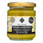 Twelve identical 190g glass jars of pickled lemon paste sit shrink-wrapped in a rectangular tray. Each jar shows a white-and-green label with the brand name, translucent glass revealing vibrant yellow paste; metal lids reflect light. They are arranged in neat rows on a plain background. Faint glare.