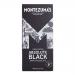 A neat arrangement of twelve matte black chocolate bars fills the frame. Each 90g bar displays Montezuma’s branding and '100% Cocoa' text on stark black packaging, with minimal accents and high-contrast typography against the dark wrappers.