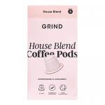 A kraft-colored cardboard box sits open to reveal neat rows of light-brown compostable coffee pods stamped with the Grind Coffee Roasters logo. Minimalist packaging shows weight and circle compost icon, with a clean grocery shelf backdrop and soft natural lighting. Matte finish and recyclable label.