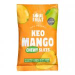 Image shows a small, vibrant orange-yellow pouch labeled Soul Fruit with bold typography. A clear window reveals glossy, irregular soft-dried mango slices stacked inside. The bag rests on a plain white surface with soft shadowing.