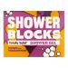 Six vibrant mango-orange solid shower gel blocks sit arranged on a white ceramic tray. Tropical fruit illustrations and sliced mangoes and passionfruit cluster nearby. Soft natural light casts gentle shadows; a folded towel and green leaves add lifestyle context. Subtle condensation dots the surface.