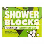 Six compact lime-green solid shower blocks rest on a wooden tray, grouped with fresh lime halves and slender sandalwood sticks. Water droplets bead on textured surfaces under soft natural light, set against neutral ceramic tiles and a folded beige towel in the background. Soft, low shadows surround.