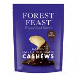 A glossy 120g Forest Feast packet of dark chocolate cashews sits among a neat array of eight identical packs on a neutral surface. The brown wrapper features chocolate swirls, whole cashews peeking through imagery, green brand accents and bold white lettering of the product name. Matte sheen catches.