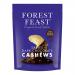 A glossy 120g Forest Feast packet of dark chocolate cashews sits among a neat array of eight identical packs on a neutral surface. The brown wrapper features chocolate swirls, whole cashews peeking through imagery, green brand accents and bold white lettering of the product name. Matte sheen catches.