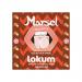 A rectangular box of Marsel Delights pomegranate lokum displays six individually wrapped squares. The glossy red and gold packaging features pomegranate illustrations and delicate script. One piece is sliced, revealing soft, pale pink Turkish delight dusted with powdered sugar. A thin glaze gleams..