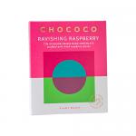 A glossy bar of deep Ecuador dark chocolate sits broken into neat squares, each surface gleaming with cocoa sheen. Bright, tangy raspberry pieces stud the chocolate, their vivid red and crumbled seeds contrasting sharply with the rich, almost-black chocolate. Flecks of cocoa powder dust the surface.
