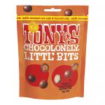 A stack of eight bright, irregularly wrapped 100g bars displays Tony’s Chocolonely Littl' Bits Milk Caramel Sea Salt & Biscuit Mix. Bold, colorful branding with oversized logo, playful illustrations, caramel and biscuit imagery, sea-salt accents, and torn chocolate pieces visible. Soft studio lighting
