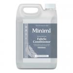A large 5L Miniml Fabric Conditioner bottle labeled Fresh Linen stands beside a smaller Miniml cleaning bottle and a refill pouch. Clean white and pale blue labels, simple minimal branding, soft lighting, gentle shadows, and a neutral surface highlight the products' shapes and textures subtle sheen.