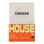 A photo shows six 200g bags of Caravan Coffee Roasters House Ground arranged in two rows. Each matte kraft-style pouch displays the Caravan Coffee Roasters logo and clear label text, simple graphic accents, and a sealed top, set on a neutral backdrop.