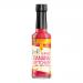 Six slim bottles of deep-red Filipino-style banana ketchup stand in a neat row against a neutral background. Each 150 ml bottle displays a RoniB’s Kitchen label with bright lettering and a banana illustration, capped in red.