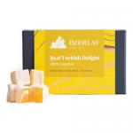 A festive display shows six Ozerlat Real Turkish Delight Zesty Lemon 200g packs arranged in a neat stack. Bright yellow packaging features lemon slices and subtle snowflakes. A clear window reveals pale yellow, sugar-dusted cubes and a small holly sprig and ribbon accent. Soft light reveals texture.
