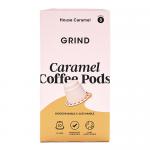 A photo shows a rectangular carton of Grind Coffee Roasters Caramel Blend beside ten home-compostable single-serve pods organized in two neat rows. The pack uses warm caramel-brown graphics with white logo text, compostable iconography and a visible 90g weight label.
