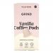 Packaged compostable coffee pods sit aligned in a neat grid beside a stacked box bearing the Grind Coffee Roasters logo and ‘Vanilla Blend’ label. Cream and earthy brown tones dominate, with minimalist typography, pod wrappers showing subtle leaf icons and weight details. Soft light reveals texture.