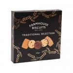 Photo shows a black rectangular selection box with gold serif lettering and a vintage bakery crest. A transparent window reveals eight assorted golden-brown biscuits arranged on parchment. The box rests on a rustic wooden surface beside sprigs of wheat and a folded linen. Soft warm glow brings out grain.