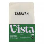 Six 200g Caravan Coffee Roasters bags sit in a neat group on a white background. Each matte pouch shows a minimalist label with the Caravan logo and 'Vista' name in muted earth tones and a resealable zip. A small pile of dark roasted beans rests in front.
